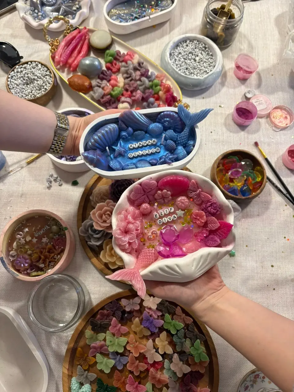 Mum workshopunda masada süslenen deniz kabuğu ve çiçek mumlar