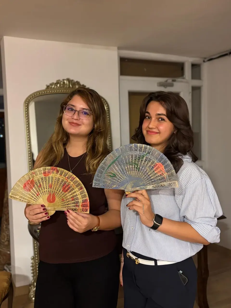 Ebru desenli yelpazelerini gösteren iki katılımcı